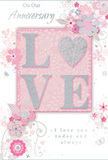 This anniversary card design radiates a feeling of intimate celebration, as if it were the paper equivalent of a hand-tied bouquet delivered quietly to a Millwall doorstep. At its centre, the word LOVE is beautifully rendered in raised lettering, each letter coated in fine, shimmering glitter that catches the light without overwhelming the soft colour palette. The glitter appears silvery and pearlescent, lending a tactile richness that would feel slightly textured beneath the fingertips. This central word is set against a blush-pink panel, warmer than the surrounding background, drawing the eye gently inward. Encircling the LOVE motif, delicate pastel flowers, swirling stems, and graceful leaves sweep across the card in a loose, almost whimsical pattern. The blooms are illustrated in shades of blush pink, soft mauve, pearly white, and pale grey, with tiny silver accents that recall the quiet sheen of water by Millwall Dock at dusk. Their outlines are fine and airy, like an artist's sketch for an anniversary arrangement filled with roses and spring blossoms. Tiny butterflies, curling tendrils, and scattered petals add light movement, suggesting the flutter of emotion that comes with remembering shared years together. The background is a gentle wash of pinks and soft neutrals, free from harsh edges, creating a calm, romantic atmosphere. Flowing calligraphy spells out anniversary sentiments such as On Our Anniversary and I love you today and always, tying the visual elements together. Overall, the card feels refined, tender, and timeless, an ideal companion for locally delivered anniversary flowers in the Millwall area.